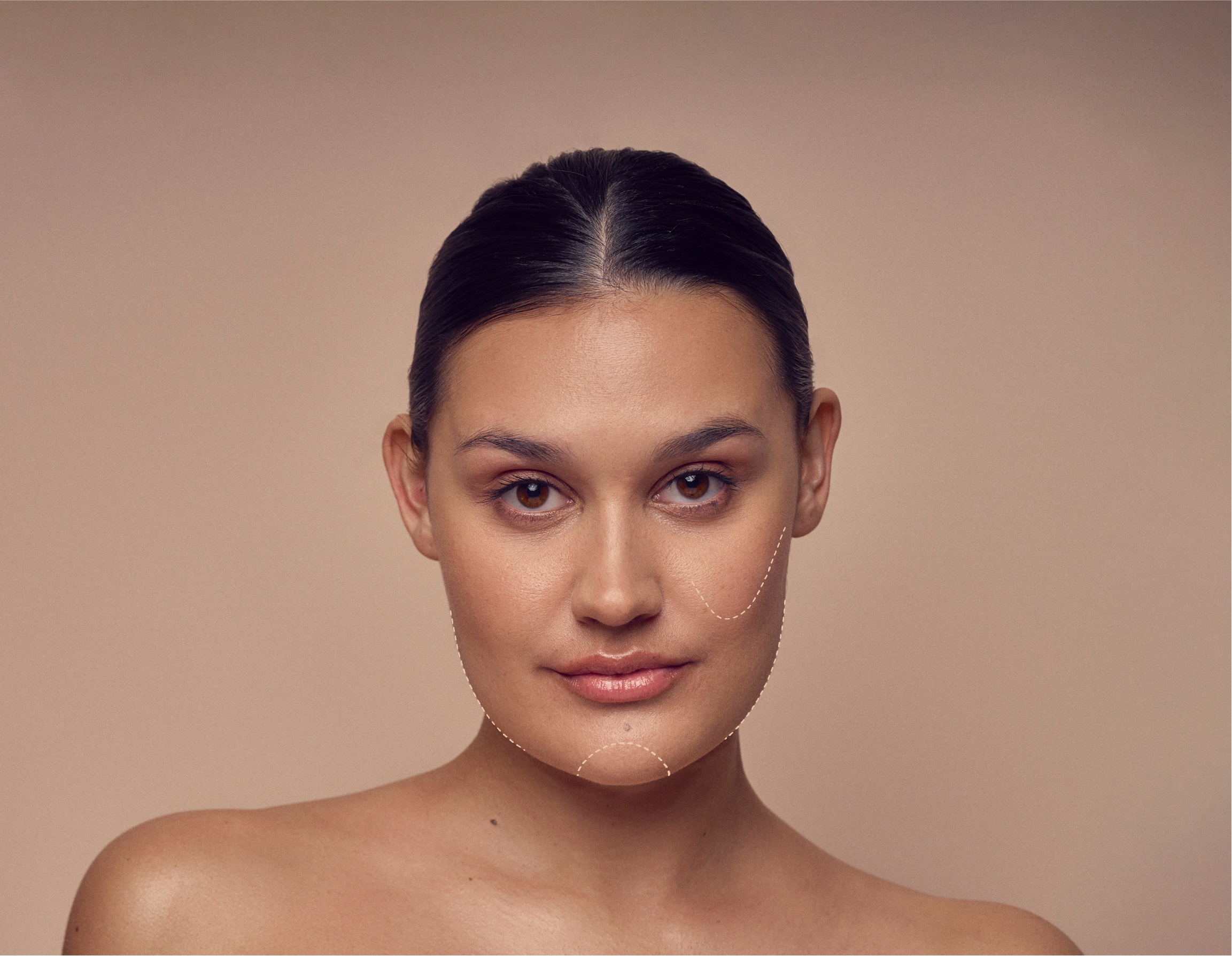 A woman with dark hair tied back gazes at the camera against a neutral background. Her face is highlighted with dotted lines, possibly indicating areas for cosmetic treatment or skincare focus. She has a calm and confident expression.